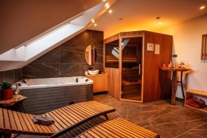 a large bathroom with a tub and a sink at Hotel Frost in Maribor
