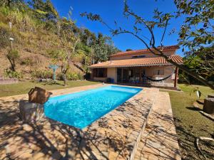 an image of a house with a swimming pool at Casa de campo Bela Vista com Piscina na montanha in Piracaia