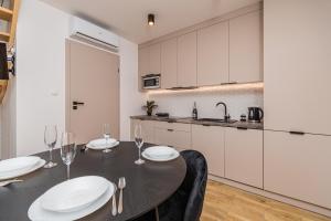 a kitchen with a table and chairs with wine glasses at Morska Oaza Jantar in Jantar +16 photos
