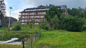特鲁特诺夫Krásný apartmán u sjezdovky v Janských Lázních的大型建筑前的游乐场