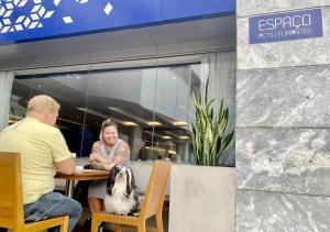 een man en een vrouw aan een tafel met een hond bij Riale Brisa Barra in Rio de Janeiro +96 foto's