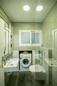 a bathroom with a washing machine and a sink at Calliope Luxury Apartment in Sitia