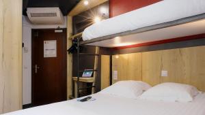 a bedroom with a bunk bed with white sheets at In Hotel Nancy Frouard in Frouard