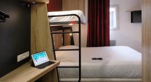 a room with a bunk bed and a laptop on a desk at In Hotel Nancy Frouard in Frouard