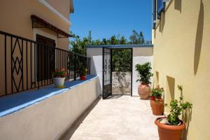 a balcony with potted plants on the side of a building at SOL Aegina Town House in Egina