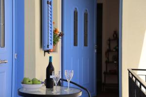 a blue door with a bottle of wine and two glasses at SOL Aegina Town House in Egina