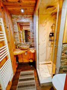 a bathroom with a shower and a sink at DOMEK NA GÓRACH z GORĄCĄ BALIĄ i SAUNĄ in Nowy Sącz