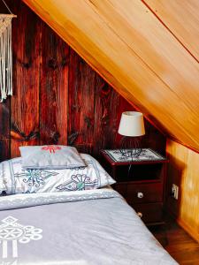 a bedroom with a bed and a table with a lamp at DOMEK NA GÓRACH z GORĄCĄ BALIĄ i SAUNĄ in Nowy Sącz