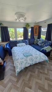a bedroom with a bed and a blue couch at Midden Manor: Farm stay in rural County Antrim. in Cullybackey