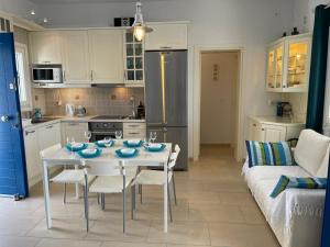 a kitchen with a white table with chairs and a refrigerator at Karras House in Kimolos