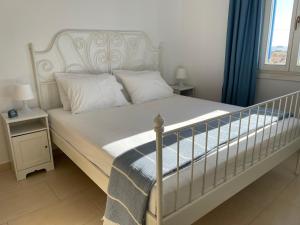 a bedroom with a white bed and a window at Karras House in Kimolos