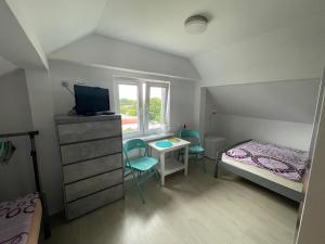 a small bedroom with a bed and a table and chairs at Pokoje i domki letniskowe BROS in Dziwnów