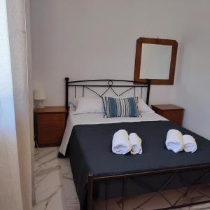 a bedroom with a bed with towels on it at Voukamvilia apartment in Paralia Kimis