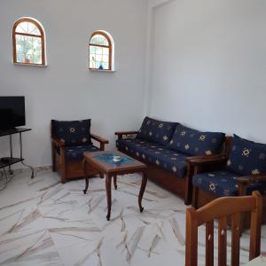 a living room with couches and a table and a tv at Voukamvilia apartment in Paralia Kimis