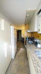 a kitchen with a sink and a refrigerator at Habitación silenciosa Nº2 en Dpto Compartido in Cordoba