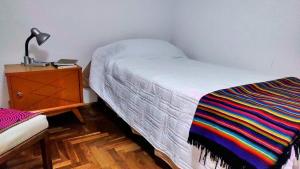 a bedroom with a bed and a dresser with a lamp at Habitación silenciosa Nº2 en Dpto Compartido in Cordoba +4 photos