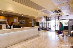 Casa2_Praia_Beach_House في بورتيماو: لوبي فندق فيه ناس تقف في كونتر +56 صورة