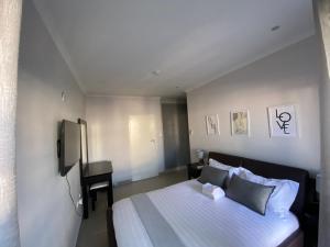 a bedroom with a large bed and a desk at Sunshine Condo in Gaborone +11 photos