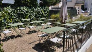 a row of tables and chairs with an umbrella at Hotel Anne De Bretagne BLOIS in Blois