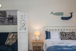 a bedroom with a bed and a table with a lamp at Direct Beach Access at OceanBreeze in Kingsburgh +31 photos