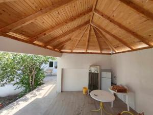 a kitchen with a wooden ceiling with a table and a refrigerator at Pansion Ajlin in Blagaj