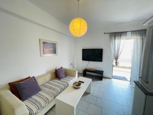 un salon avec un canapé et une télévision dans l'établissement Akrata v apartment, à Akrata