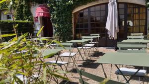 a row of tables and chairs with an umbrella at Hotel Anne De Bretagne BLOIS in Blois +30 photos