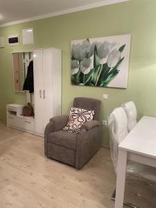 Una sala de estar con una silla y un cuadro en la pared. en Studio Vila Roma, en Nesebar