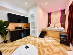 Una pequeña habitación con una cama y una cocina. en Intimate Escape - Seaside - Spa Bath - WIFI - AC, en Niza