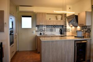 une cuisine avec des armoires en bois et un comptoir dans l'établissement Gîte Confortable Vue Exceptionnelle - Golf de Saumane, à Saumane-de-Vaucluse