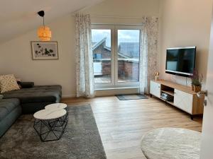 a living room with a couch and a television at Ferienwohnung Sonnendeck in Kranenburg