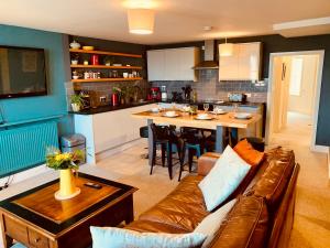 a living room and kitchen with a couch and a table at Vibrant beachfront Folkestone getaway in Folkestone