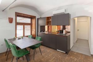 cocina con mesa y sillas verdes en Aroma apartments, en Liubliana