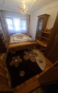 a bedroom with a bed with a rug and a chandelier at Apartament Ania&Maria in Băile Herculane