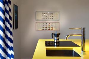 una cucina con bancone giallo e lavandino di Galleria Port'Alba - Suites & Rooftop a Napoli Altre 104 foto