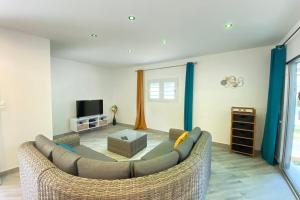 a living room with a couch and a tv at 972M Beautiful air-conditioned villa with garden in Le Carbet