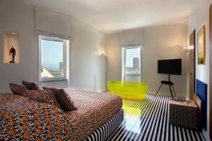una stanza d'albergo con un letto e una sedia gialla di Galleria Port'Alba - Suites & Rooftop a Napoli