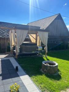 a patio with a couch and curtains in a yard at Siedlisko Pod Babią Góra in Lipnica Wielka