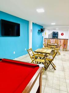 a room with tables and chairs and a flat screen tv at Hostel Recanto da Paciência in Salvador