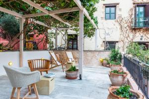 a patio with chairs and a pergola at Hotel Off in Chania Town