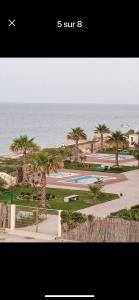 a view of a resort with palm trees and the ocean at Residence amwej sousse in Sousse