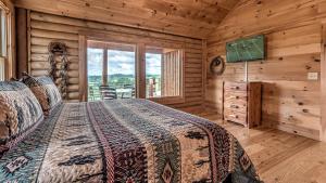 a bedroom with a bed and a television in a log cabin at Yellowstone Lodge in Blue Ridge