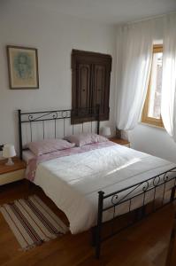 a bedroom with a large bed with white sheets and a window at Apartments Boscarin in Buje
