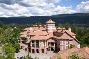 a large pink building with a tower on top of it at Borgata Lodge Resort in Kelowna