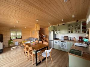 a kitchen and dining room with a wooden ceiling at Woodstock in Krajnik Dolny
