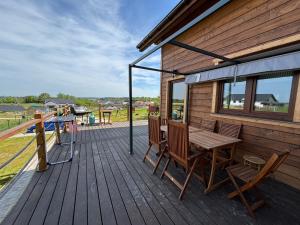 a wooden deck with a wooden table and chairs at Woodstock in Krajnik Dolny