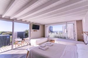 Un dormitorio con una cama y una ventana grande. en Departamento frente al mar Sauce Grande REFUGIOS DEL SAUCE, en Monte Hermoso