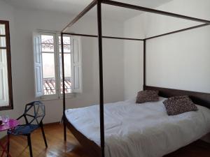 a bedroom with a four poster bed and a chair at Casa Cañas-Catedral de León in León