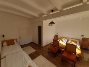 a bedroom with a bed and two chairs and a table at Halászmester Vendégház in Nagykörů