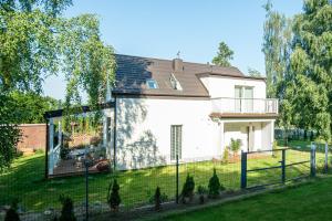 a white house with a fence in the yard at Leo House in Gdynia
